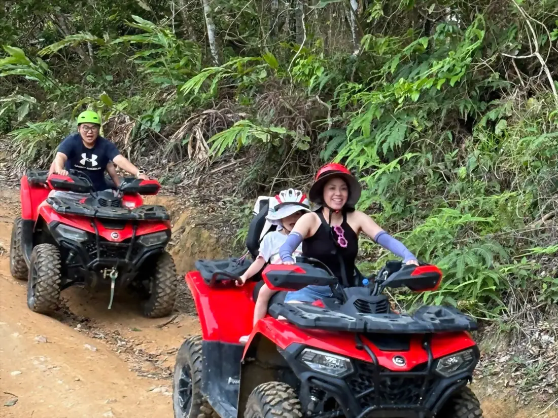 Family riding quads with a child passenger on the trails of Koh Samui